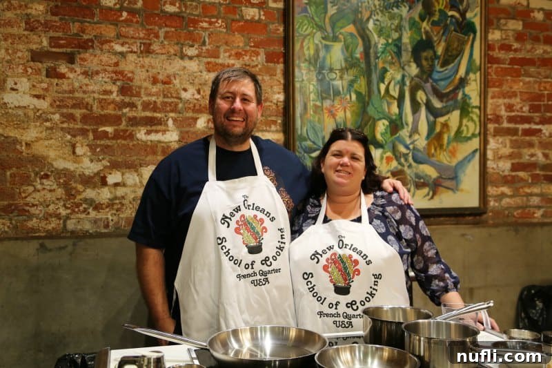 Tammilee and John wearing aprons at the New Orleans School of Cooking