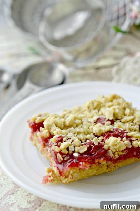 A delicious cherry cake bar with a spoon in the background, ready to be enjoyed.