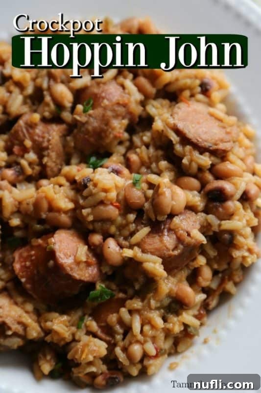 Crockpot Hoppin John served over a white plate, piled high with rice, kielbasa, and black-eyed peas.