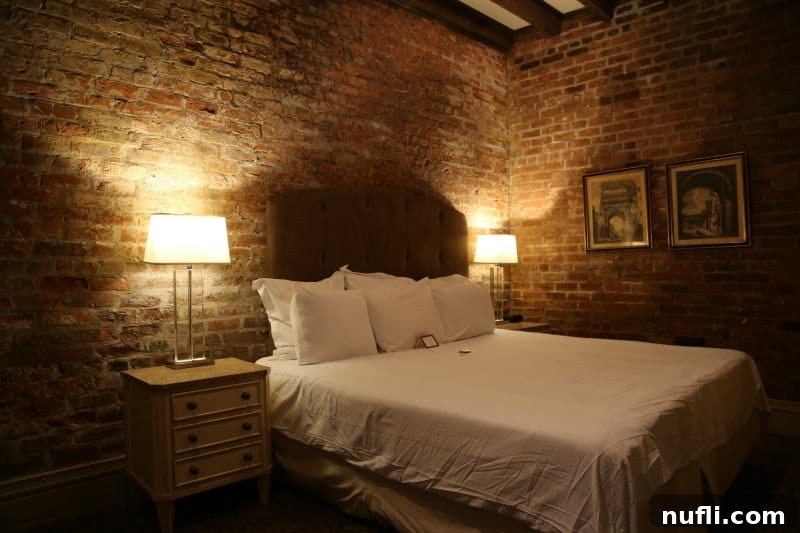 Dauphine Orleans Hotel New Orleans 3 Hotel room with brick walls, bed, and art on the wall