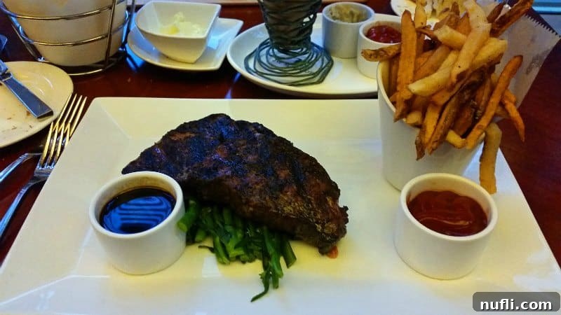 A delicious steak and crispy fries perfectly presented on a white plate, ready to be enjoyed.