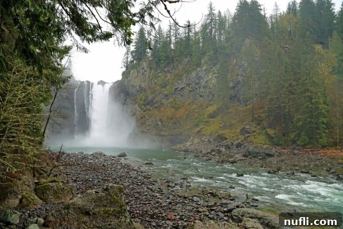 Snoqualmie Falls through the trees on a misty morning 