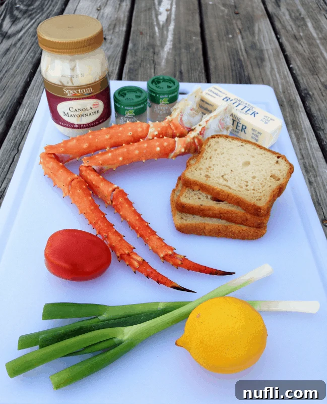 A vibrant display of fresh ingredients for making crab rolls, neatly arranged on a wooden cutting board, featuring King crab legs, creamy mayonnaise, finely chopped green onions, diced organic tomatoes, and a bright lemon.
