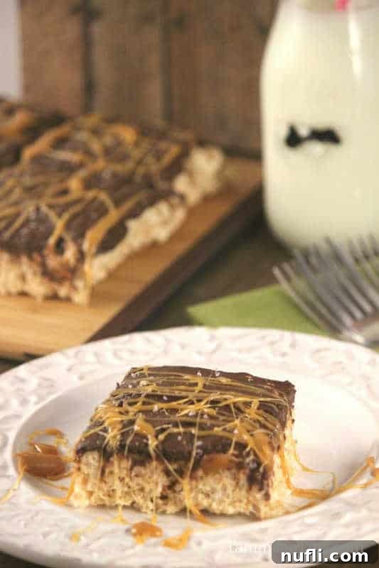 salted caramel chocolate topped rice krispie square on a white plate