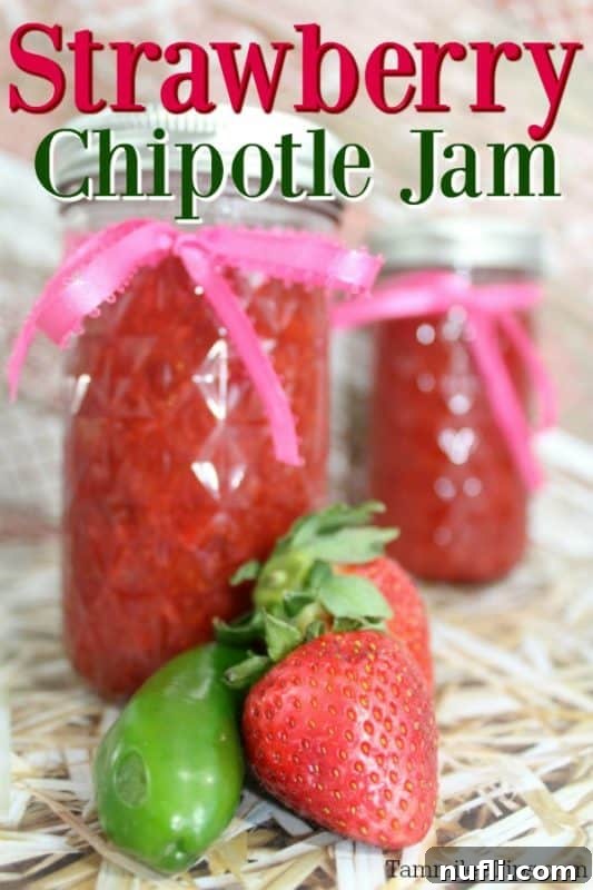 Strawberry Chipotle jam over jars of jam with a pepper and fresh strawberries