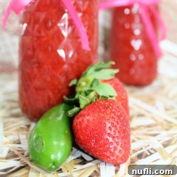 pepper and strawberry in front of strawberry chipotle jam jars