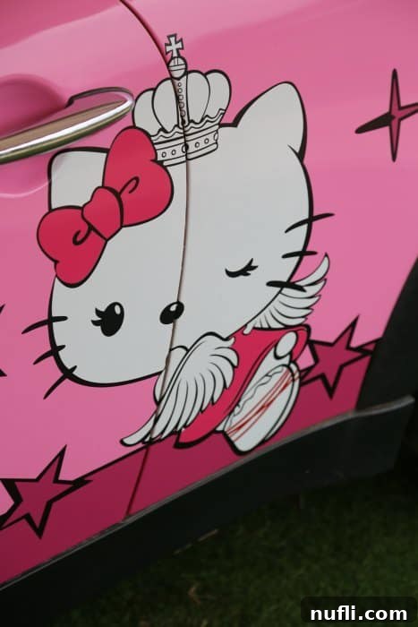 Close-up of Hello Kitty branding on the side of a themed car