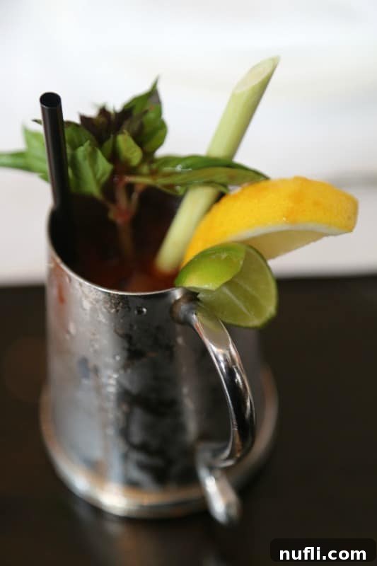 St. Regis Bangkok's Exquisite Afternoon Tea 4 A vibrant cocktail served in a sleek silver cup, embodying sophisticated refreshment.