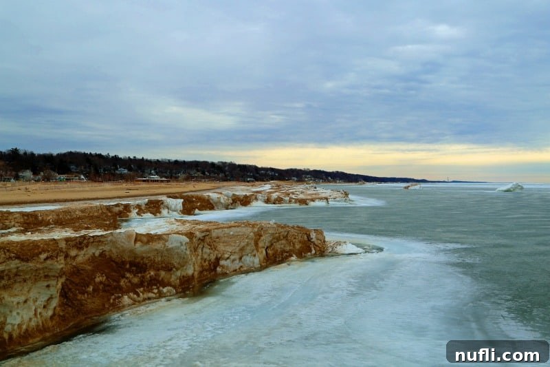 Large chunks of ice piled up along the frozen shoreline of Lake Michigan, creating a dramatic winter landscape near Grand Haven.