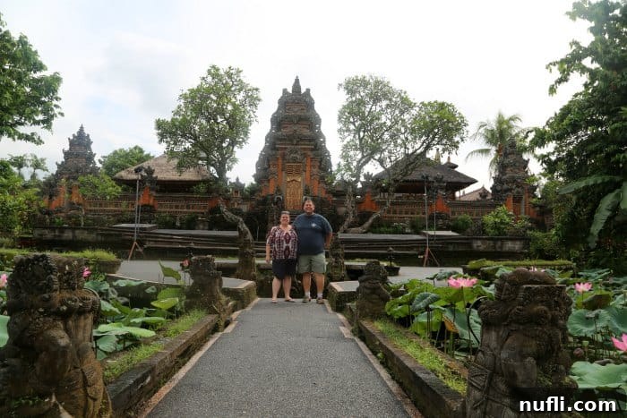 From Latte to Lotus Ubud's Starbucks and Saraswati 6 Tammilee and John posing at Saraswati Temple in Bali, showcasing the beauty of the location
