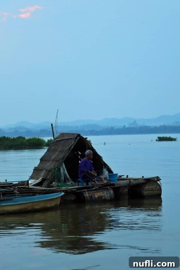 An older fisherman diligently working on the Mekong River