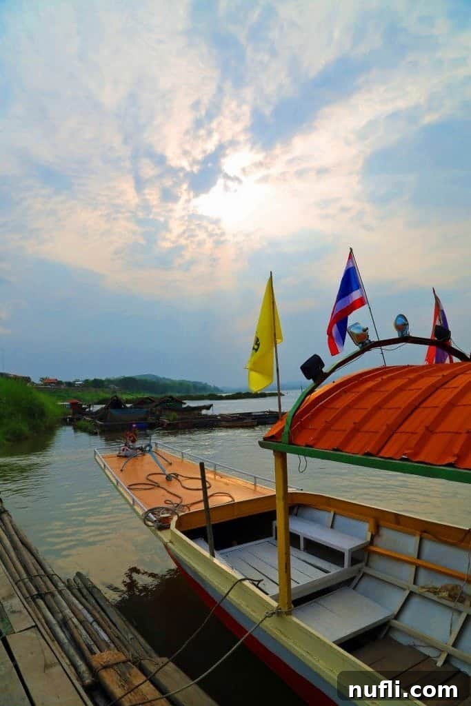 Mighty Mekong Voyage: Thailand to Laos 5 A stunning sunset paints the sky over the Mekong River, viewed from a traditional longtail boat, highlighting the tranquil beauty of Northern Thailand.