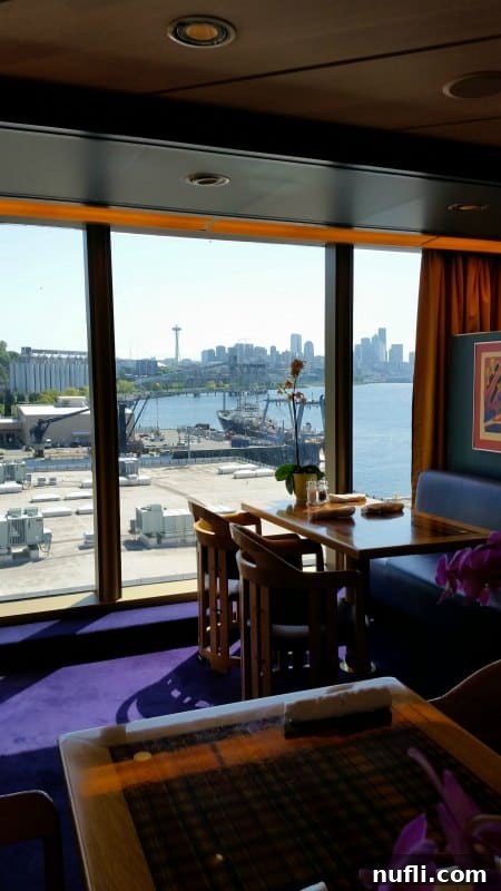 Elegant dining room on the Westerdam with expansive windows offering a clear view of the Seattle Space Needle, providing a refined ambiance for guests.
