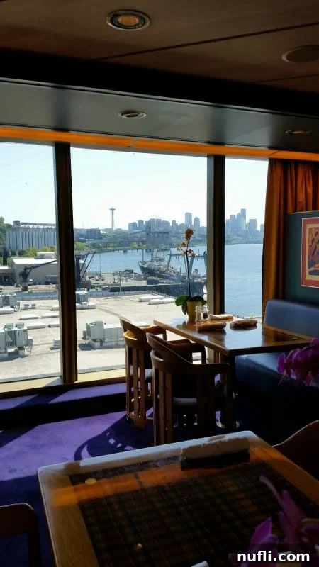 Elegant dining room interior offering stunning panoramic views, with the Seattle Space Needle visible in the distance