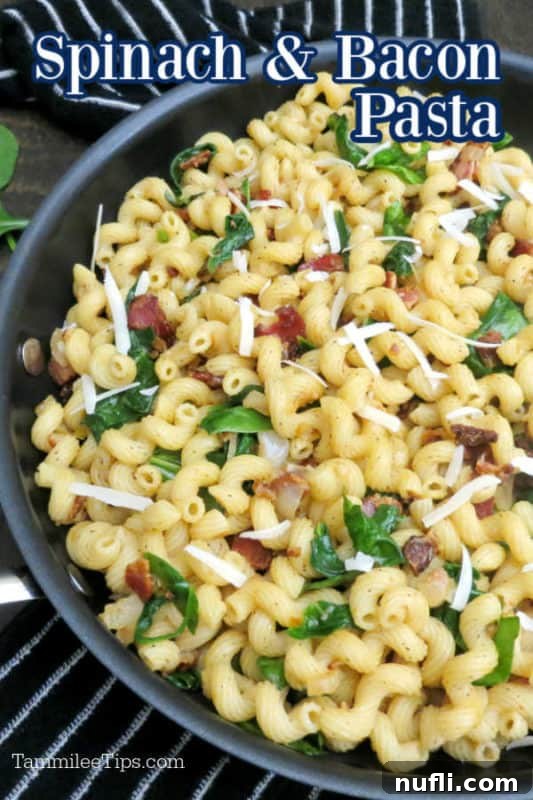 Spinach and bacon pasta over a pan of pasta with wilted spinach, cheese, and bacon