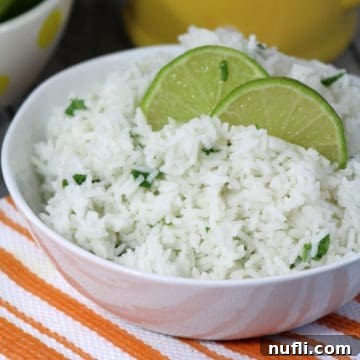 Cilantro Lime Rice in a white bowl with lime wedges.