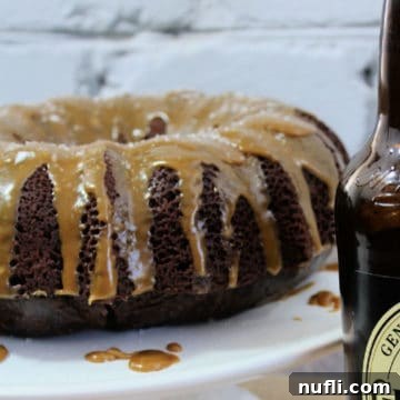 Guinness Chocolate Cake with a smooth caramel glaze drizzled over it, presented on a white platter.
