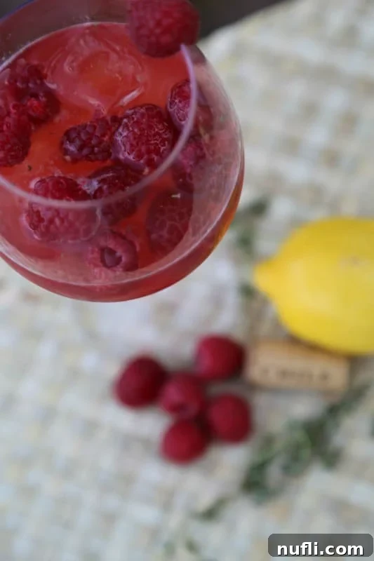 moscato wine cocktail by a lemon and raspberries