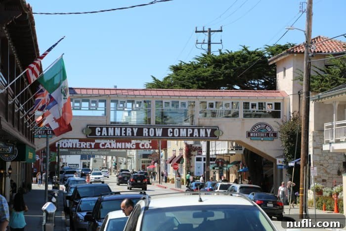 Cannery Row Commpany sign on bridge over the road with cars parked along the road