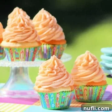 Orange Julius Cupcakes in a paper wrapper and on a cake stand