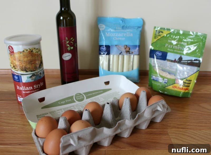 Ingredients for baked mozzarella sticks laid out: breadcrumbs, olive oil, string cheese, grated parmesan, and eggs, ready for preparation.