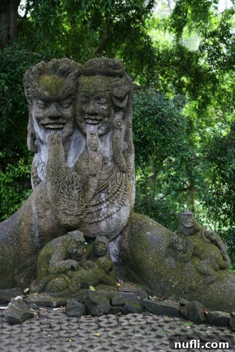 An ancient sculpture adorned with monkeys, blending art and nature in the Ubud Monkey Forest