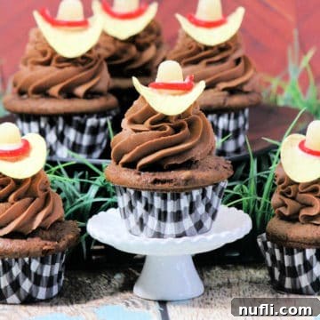 Cowboy Hat Cupcake on a cupcake stand surrounded by more cupcakes, showcasing the edible Western theme
