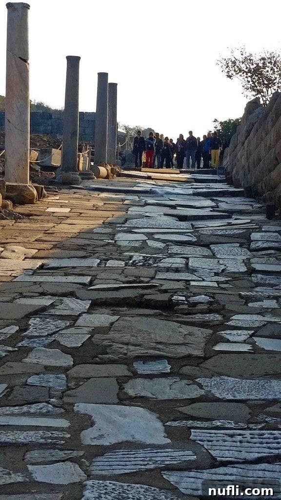 Uneven, hand-carved marble walkways in Ephesus, showcasing anti-slip grooves designed for pedestrian safety.