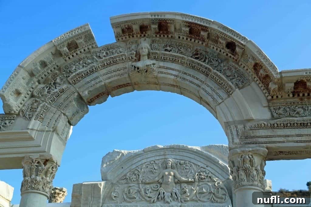 An ornate archway, possibly part of Hadrian's Temple or a similar grand structure, in Ephesus, Turkey.