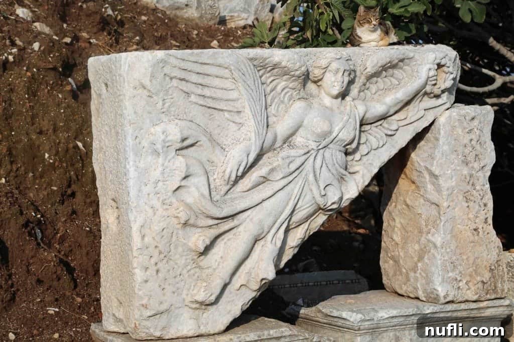 A unique sculpture of the goddess Nike, with a local cat perched atop, blending ancient and modern Ephesus.