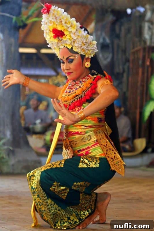 Bali's Spiritual Drama: Barong and Kris in Ubud 2 Balinese dancer adorned with a flower headdress and an exquisite traditional dress, performing a Barong and Kris Dance.