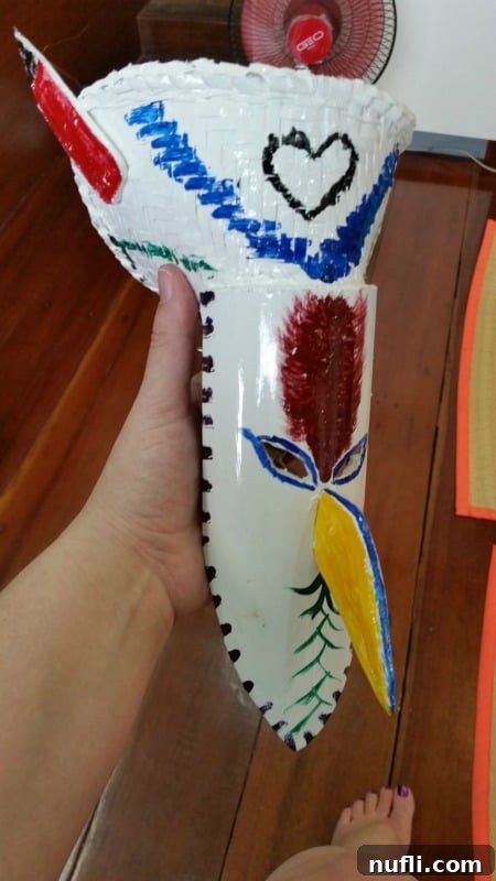 A freshly painted white Phi Ta Khon mask adorned with a vibrant red heart, symbolizing personal expression
