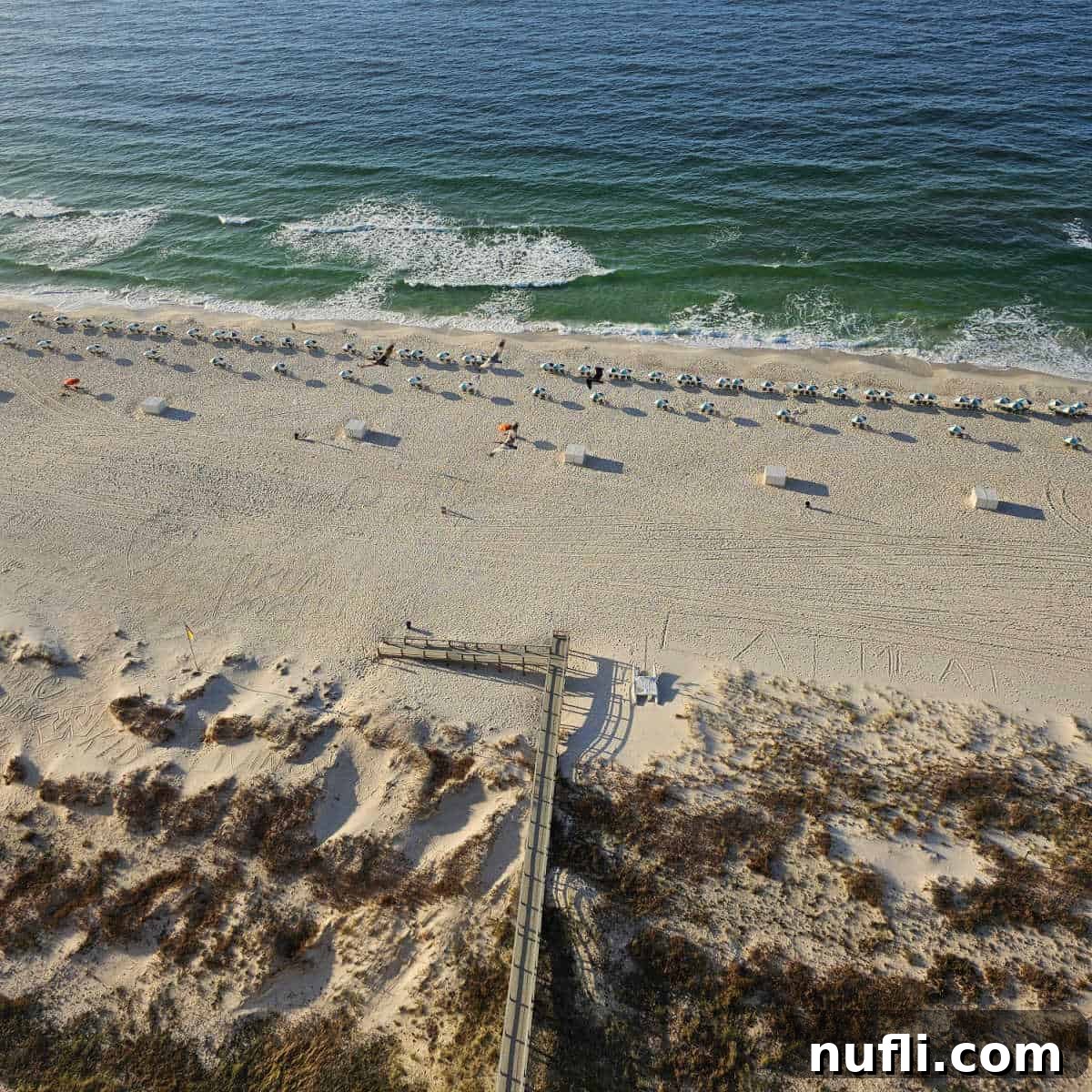 Romantic Getaways: Valentine's Day Escapes 3 Wooden boardwalk leading over sand dunes to white sand beaches with chairs and umbrellas and the coast of the Gulf of Mexico