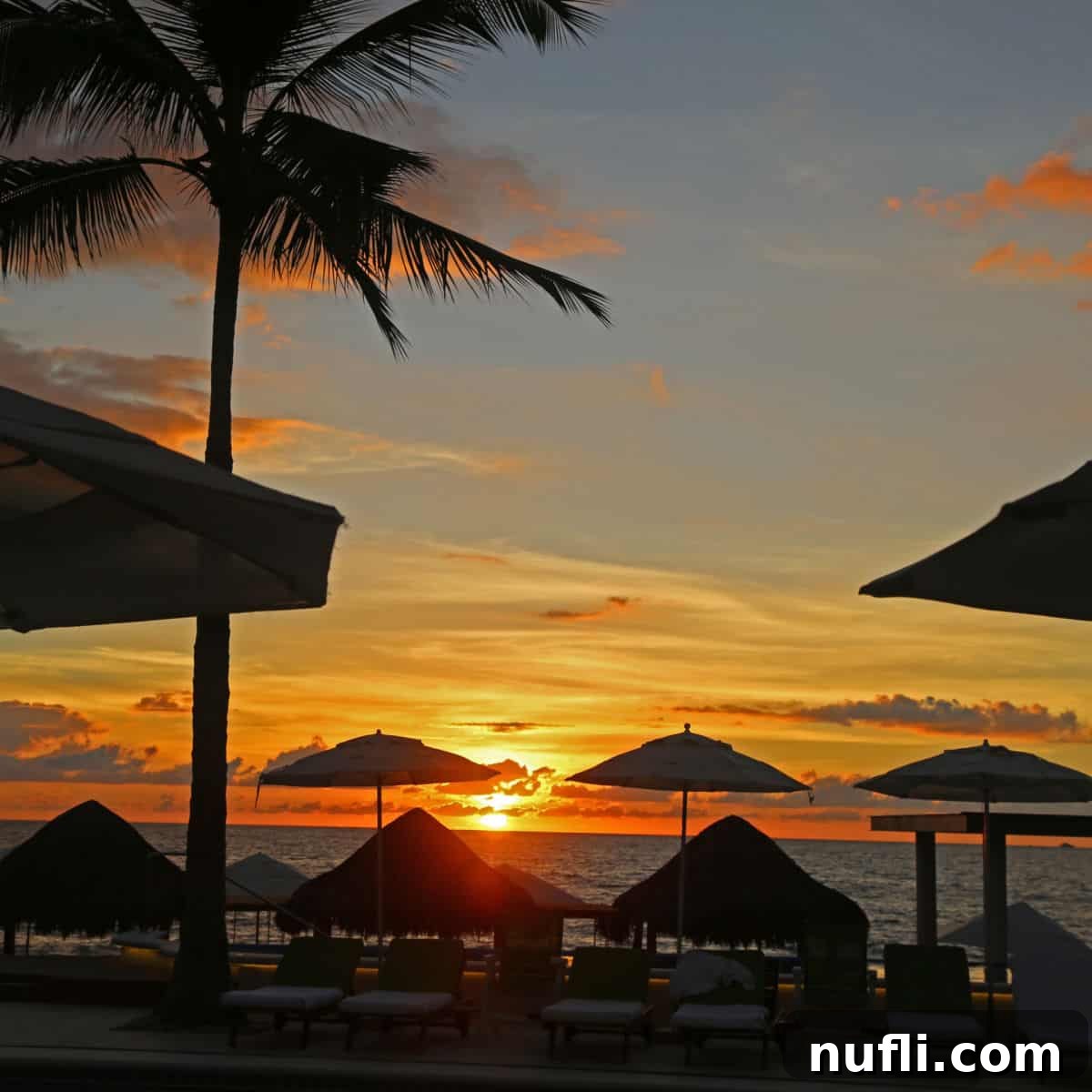 Romantic Getaways: Valentine's Day Escapes 6 Sunset over the Bay of Banderas in Puerto Vallarta through beach umbrellas